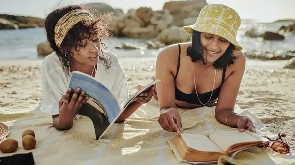 Two women reading on the beach