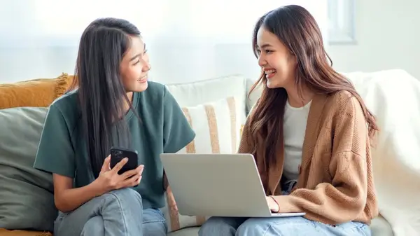 Two women talking, holding gadgets