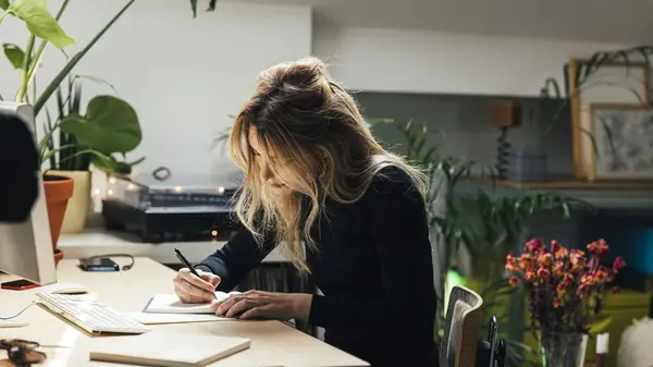 A woman journaling at her desk 