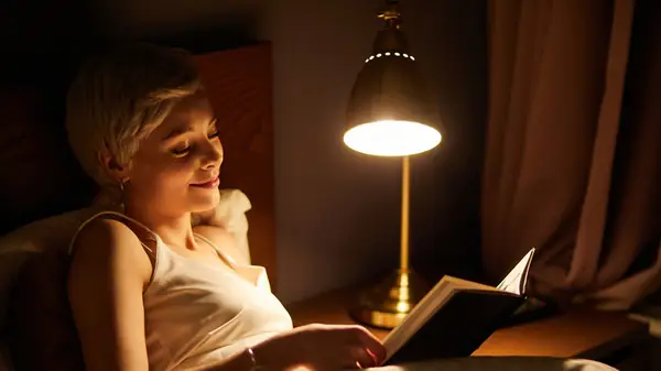 Woman reading book in bed
