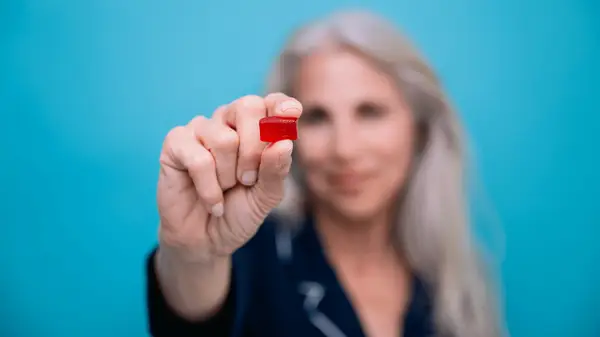 close up of woman holding a sleep gummy
