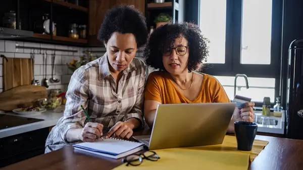 two in kitchen paying bills
