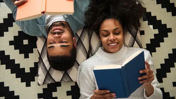 Young couple on the floor reading