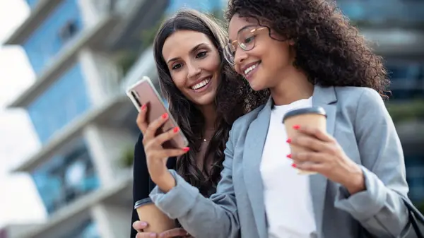 Woman showing friend her phone