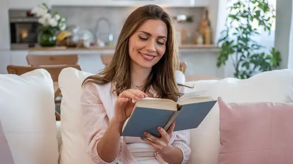 Woman reading a book on a sofa