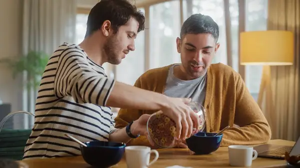 A queer couple eating together 