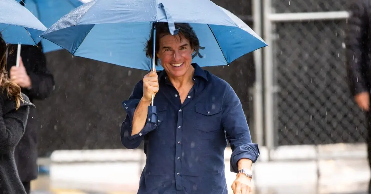 Tom Cruise souriant marchant sous la pluie