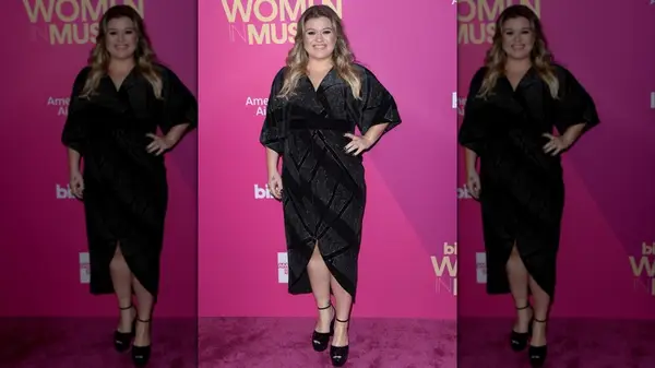 Kelly Clarkson on the red carpet in a black wrap dress