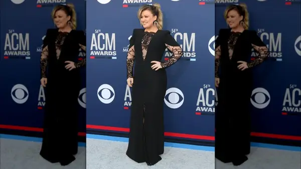 Kelly Clarkson on the red carpet in a black gown with lace details