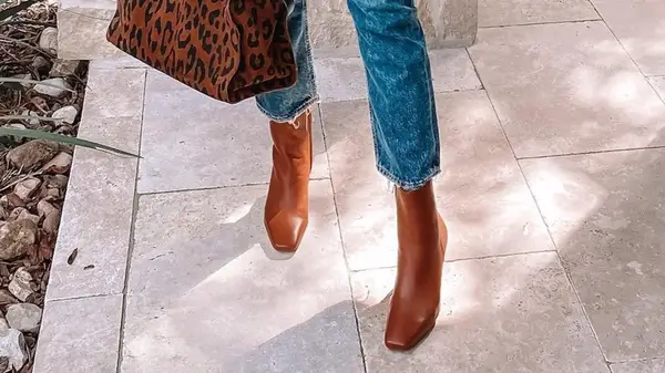 A woman wearing square-toed brown boots