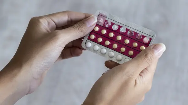 Person holding birth control pills