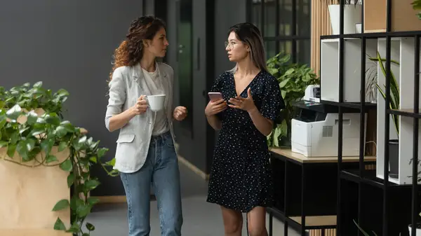 two women walking through office