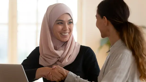 Two people talking, shaking hands