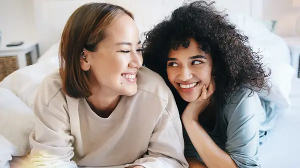 A man and woman hugging and smiling next to a kitchen sink