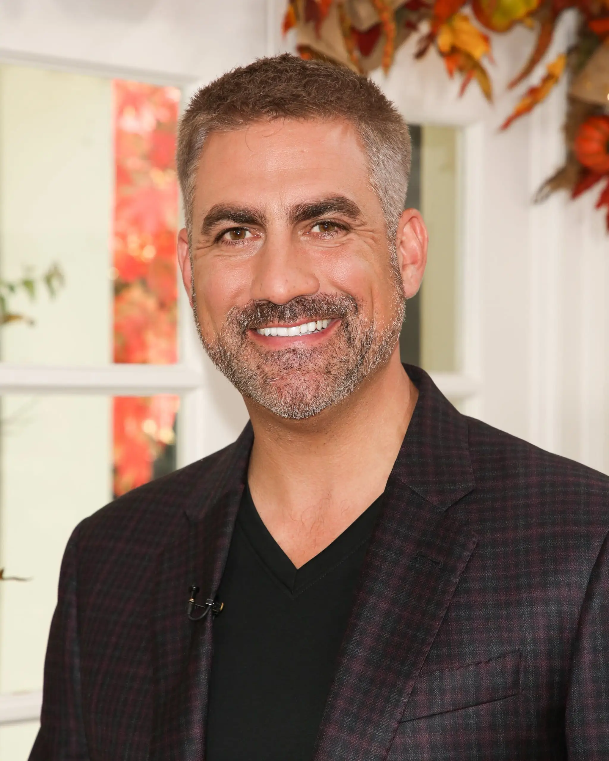 Taylor Hicks trägt einen karierten Blazer über einem schwarzen T-Shirt mit V-Ausschnitt