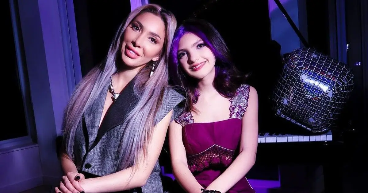 Farrah와 Sophia Abraham은 보라색 조명 아래 함께 앉아 있습니다.