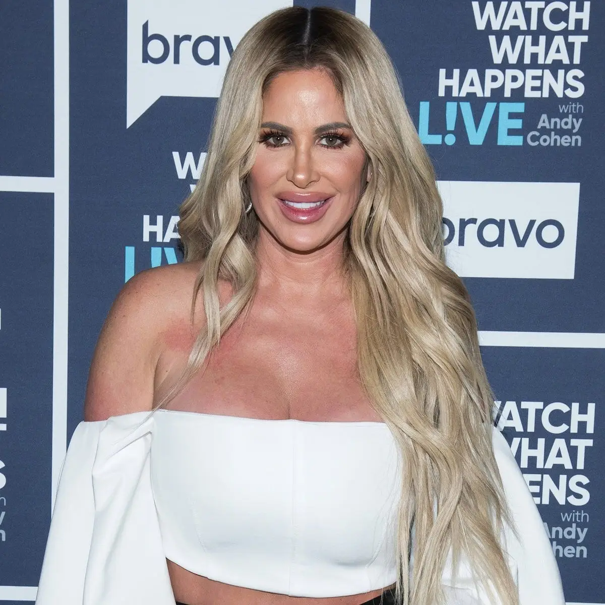 Kim Zolciak-Biermann portant un crop top blanc à manches bouffantes et épaules dénudées