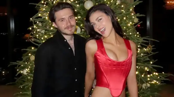 Brooklyn Peltz Beckham and Nicola Peltz Beckham posing by a Christmas tree