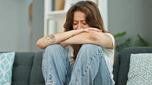 woman crying on couch