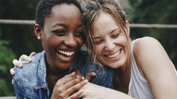 Two friends hugging and laughing