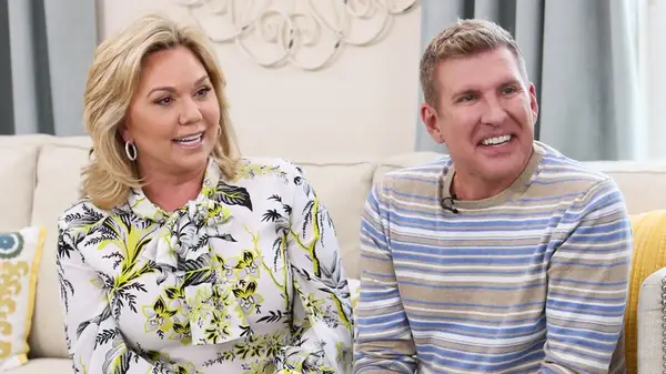 Julie Chrisley and Todd Chrisley sitting on a sofa