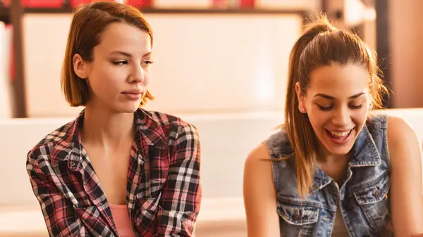 jealous woman with happy woman