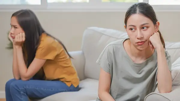 Couple sitting apart on sofa
