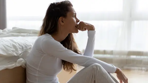 woman sitting on bedroom floor