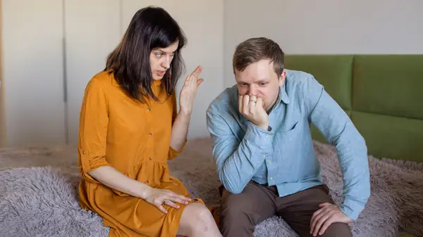 man and woman arguing on bed