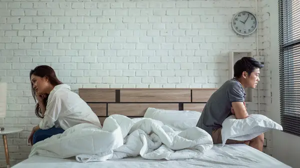 unhappy couple apart on bed