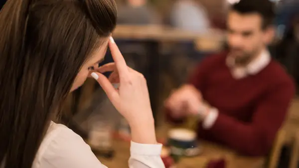 close up of woman with hand to forehead