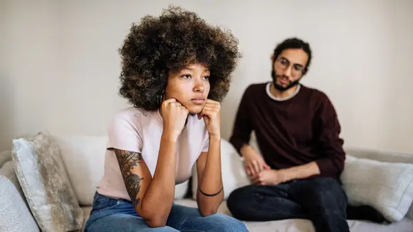 couple sitting apart on couch