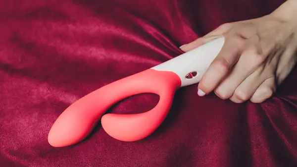 Hand holding a peach vibrator