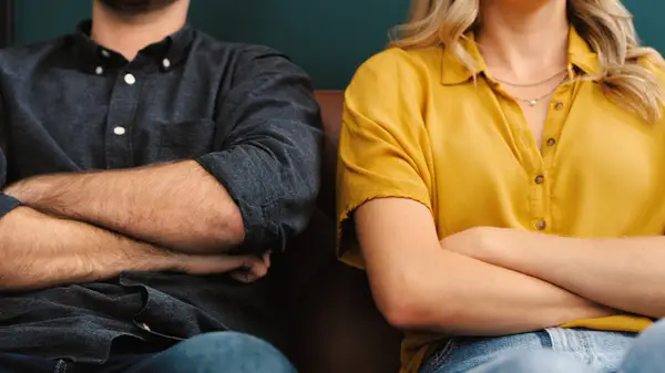 Couple sits with arms crossed
