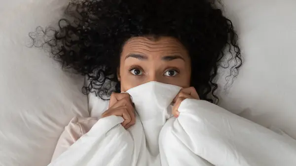 A woman bashful in bed