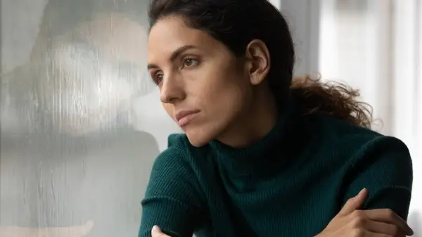 Woman looks out window