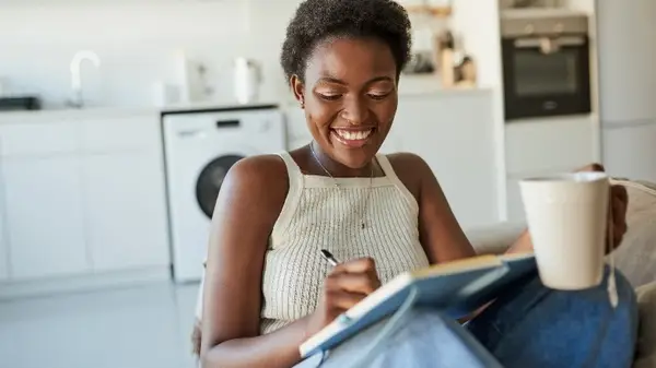 Woman writing in calendar over tea