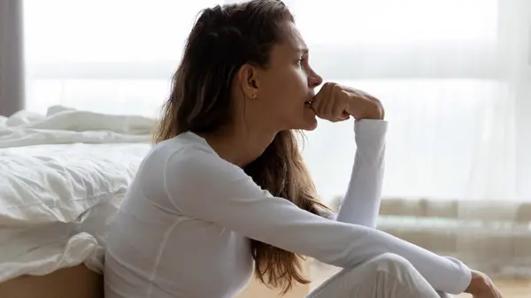 concerned woman sitting on floor