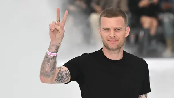 Matthew Williams giving the peace sign in a black shirt