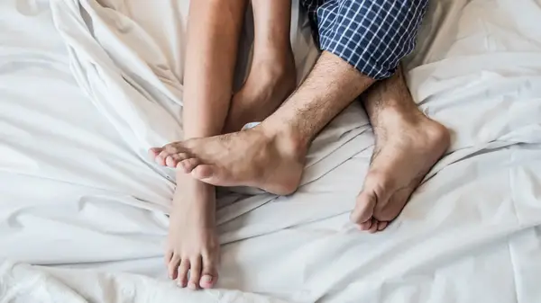 two pairs of feet in bed