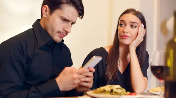 woman looking at man on phone