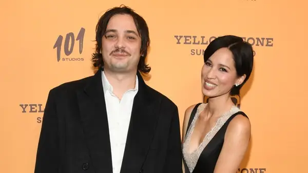 Kelsey Asbille posing with Miles Joris-Peyrafitte on the red carpet