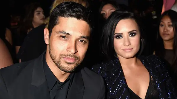 Demi Lovato sitting with Wilmer Valderrama
