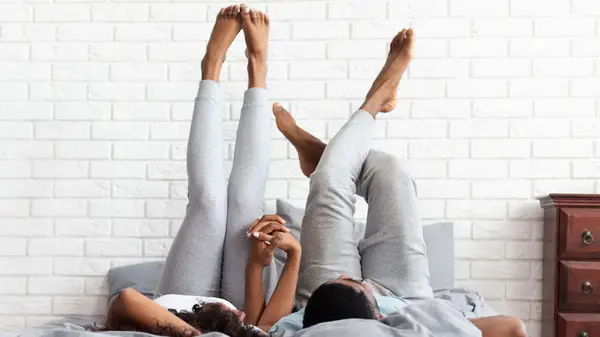 Couple in bed legs up