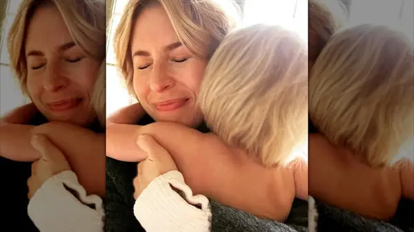 Erin Napier embracing one of her children