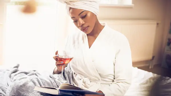 Woman reading book in robe