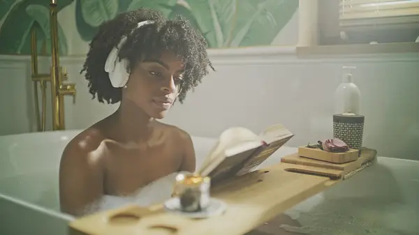 Woman reading book in bath