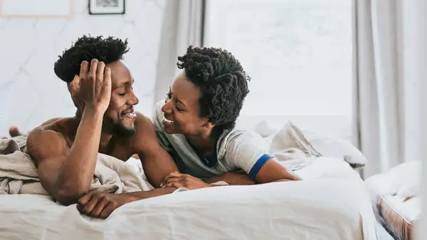 Couple in bed talking and smiling