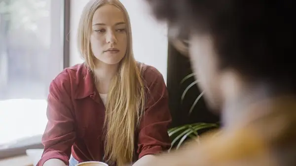 Woman looks disappointed at cafe with partner