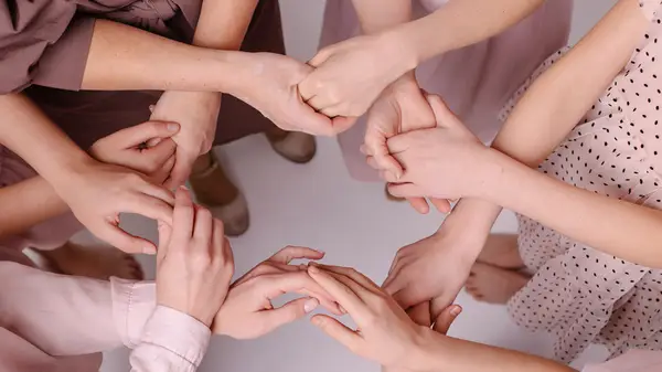 four women holding hands 